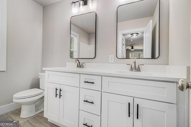 bathroom featuring hardwood / wood-style flooring, plenty of natural light, vanity, and toilet