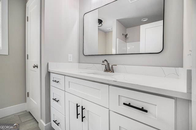 bathroom featuring a shower and vanity