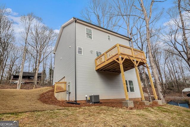 back of property with a yard, a deck, and central AC unit