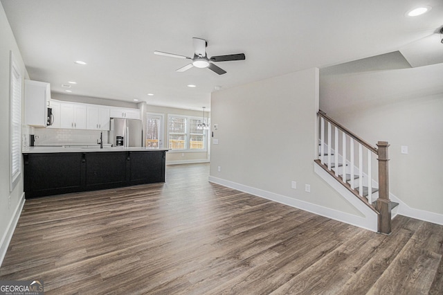 kitchen with stainless steel fridge, dark hardwood / wood-style flooring, white cabinetry, and backsplash