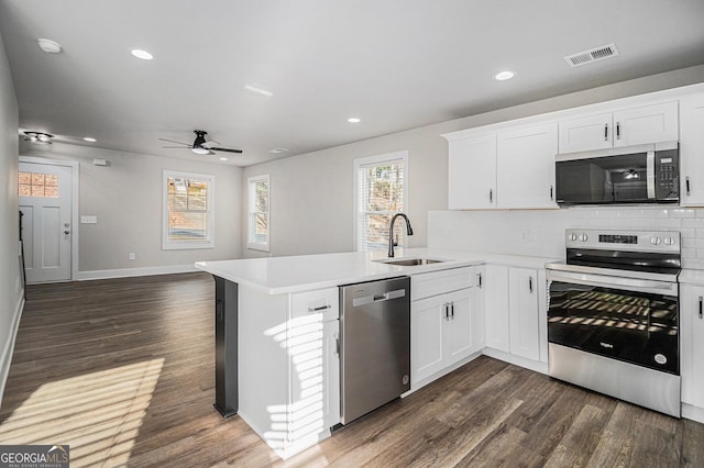 kitchen featuring kitchen peninsula, sink, white cabinets, and stainless steel appliances