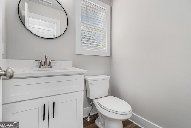 bathroom with vanity, wood-type flooring, and toilet