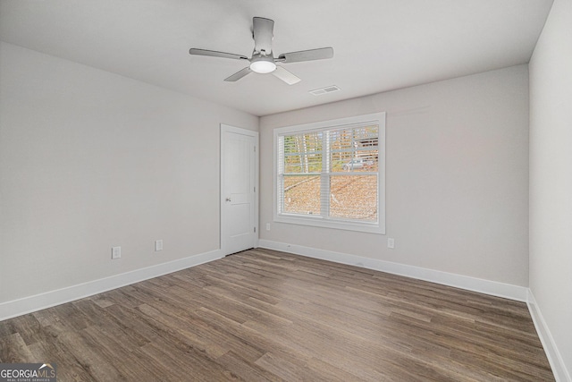 empty room with hardwood / wood-style flooring and ceiling fan