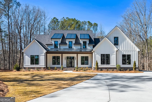 modern farmhouse style home with a front yard and a porch