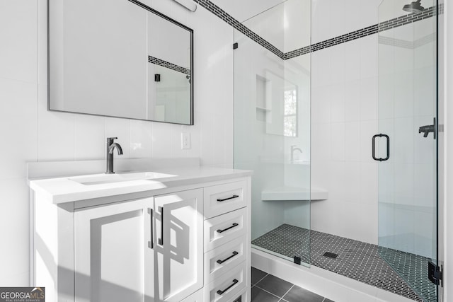 bathroom with an enclosed shower, vanity, tile walls, and backsplash