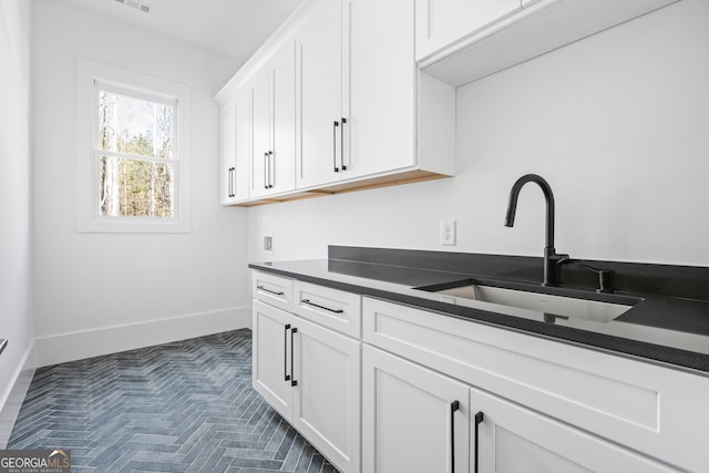 kitchen featuring white cabinetry and sink