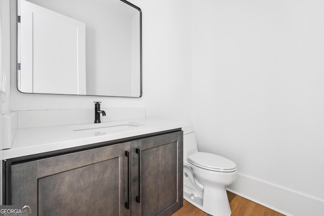 bathroom with vanity, hardwood / wood-style flooring, and toilet