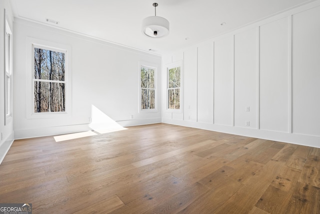 unfurnished room with hardwood / wood-style floors and crown molding