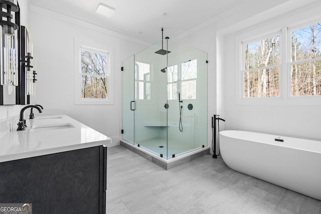 bathroom with crown molding, a healthy amount of sunlight, shower with separate bathtub, and vanity