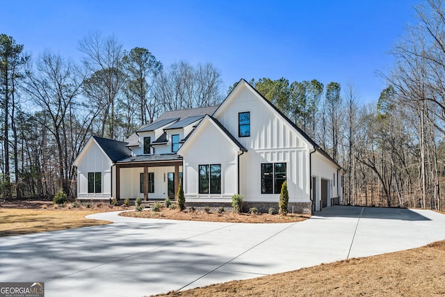 modern farmhouse style home featuring a porch and a garage