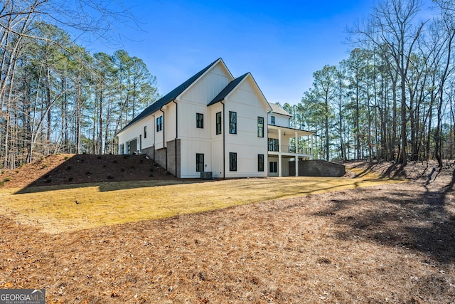 view of property exterior featuring central AC unit, a yard, and a balcony