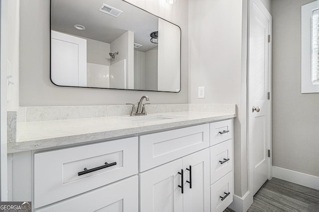 bathroom featuring a shower, hardwood / wood-style floors, and vanity