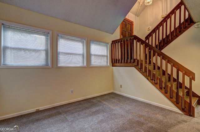 stairs with carpet floors, a wealth of natural light, a textured ceiling, and baseboards