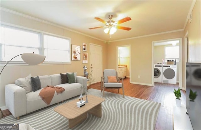 living room featuring hardwood / wood-style flooring, ceiling fan, ornamental molding, and washing machine and dryer