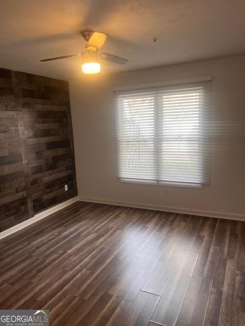 spare room featuring dark wood-type flooring and ceiling fan