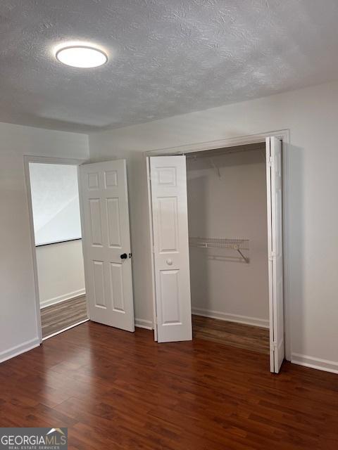 2254 Wellington Cir, Lithonia, GA 30058 - unfurnished bedroom featuring wood finished floors, a textured ceiling, and a closet