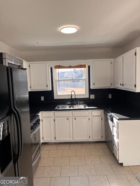 2254 Wellington Cir, Lithonia, GA 30058 - kitchen with stainless steel appliances, white cabinetry, dark countertops, and decorative backsplash