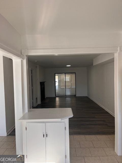 interior space with light tile patterned floors, kitchen peninsula, and white cabinets