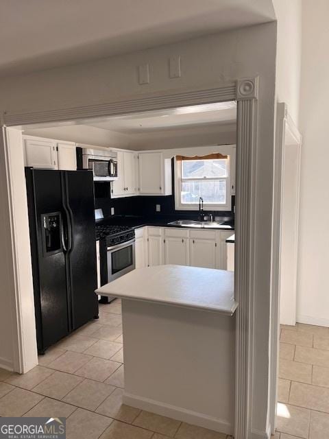 2254 Wellington Cir, Lithonia, GA 30058 - kitchen featuring appliances with stainless steel finishes, white cabinets, a peninsula, and light tile patterned floors