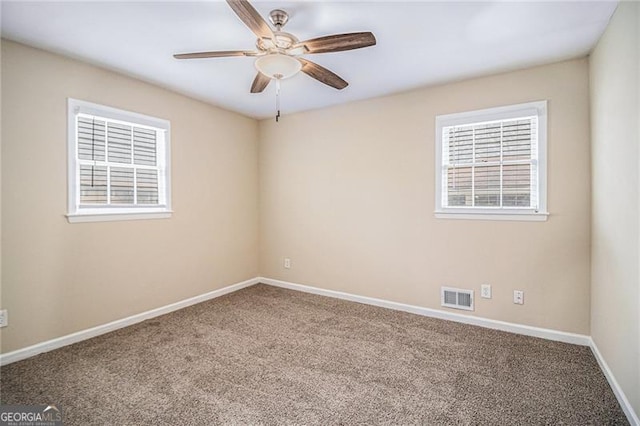 carpeted spare room featuring ceiling fan