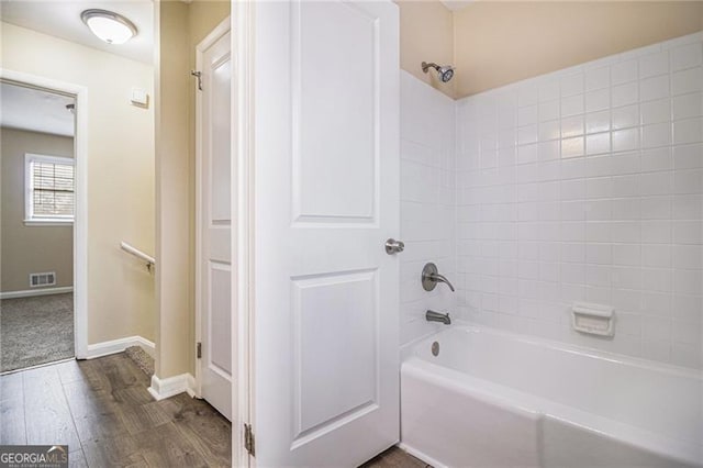 bathroom with tiled shower / bath and hardwood / wood-style flooring