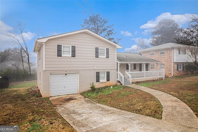 split level home featuring covered porch, a garage, and a front lawn