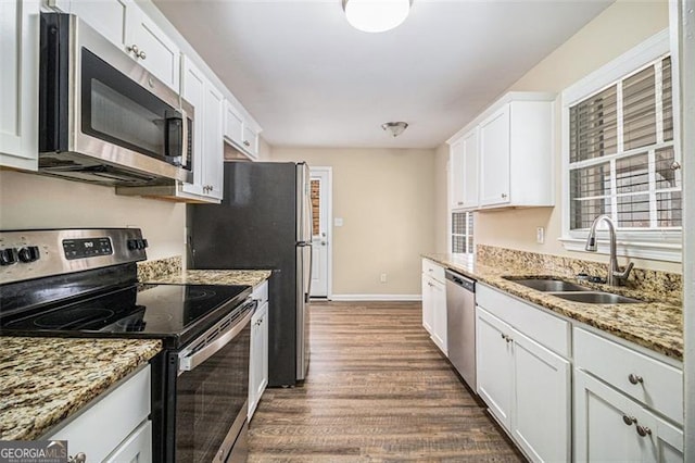 kitchen with white cabinetry, sink, light stone counters, dark hardwood / wood-style floors, and appliances with stainless steel finishes