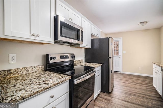 kitchen featuring white cabinets, light stone counters, dark wood-type flooring, and appliances with stainless steel finishes