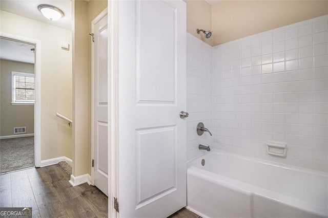 bathroom with wood-type flooring and tiled shower / bath combo