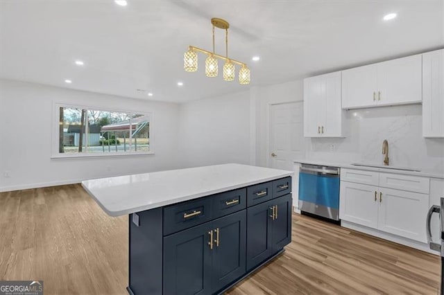 kitchen featuring backsplash, light wood-type flooring, hanging light fixtures, stainless steel dishwasher, and white cabinets