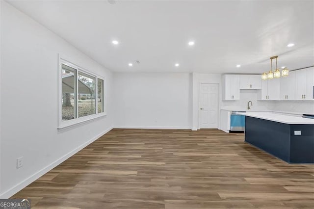 kitchen featuring dark hardwood / wood-style flooring, stainless steel dishwasher, white cabinets, and decorative light fixtures