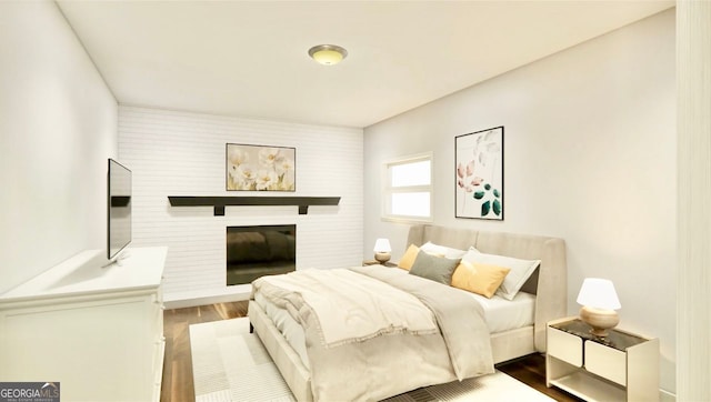 bedroom featuring hardwood / wood-style flooring and a fireplace