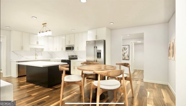 kitchen with white cabinetry, stainless steel appliances, tasteful backsplash, hanging light fixtures, and a center island