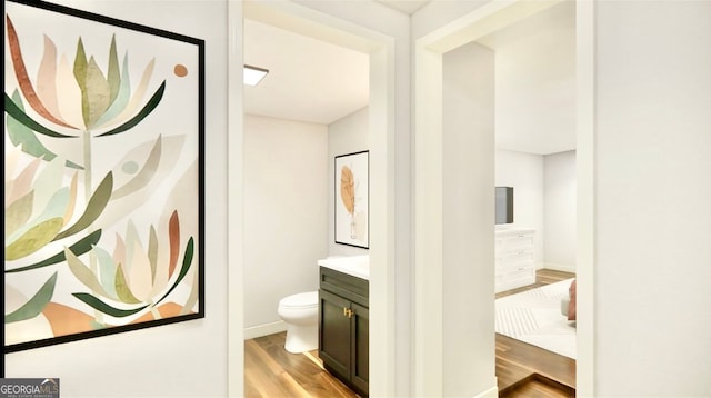 bathroom with hardwood / wood-style flooring, toilet, and vanity