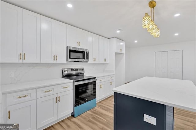 kitchen with white cabinetry, light hardwood / wood-style floors, appliances with stainless steel finishes, hanging light fixtures, and a center island