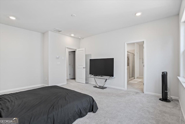 bedroom featuring connected bathroom and light carpet