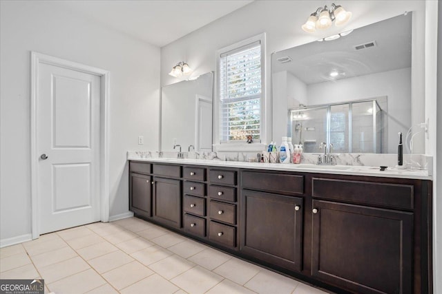 bathroom featuring tile patterned floors, vanity, and a shower with door