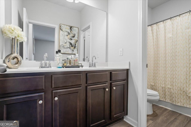 bathroom featuring vanity, hardwood / wood-style flooring, and toilet