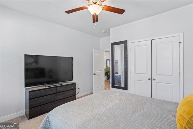 bedroom with ceiling fan, light carpet, and a closet