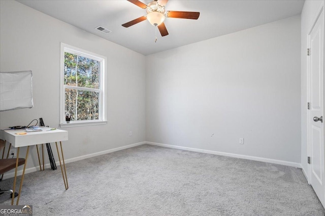 carpeted office space with ceiling fan