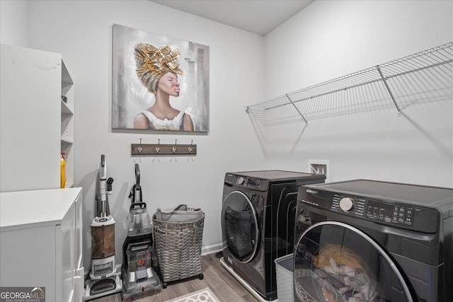 clothes washing area with washer and dryer and wood-type flooring