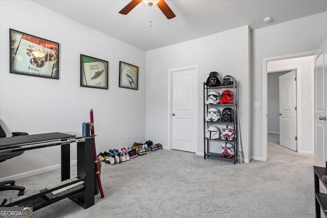 exercise room featuring ceiling fan and light colored carpet