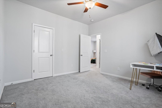 unfurnished office featuring ceiling fan and light colored carpet