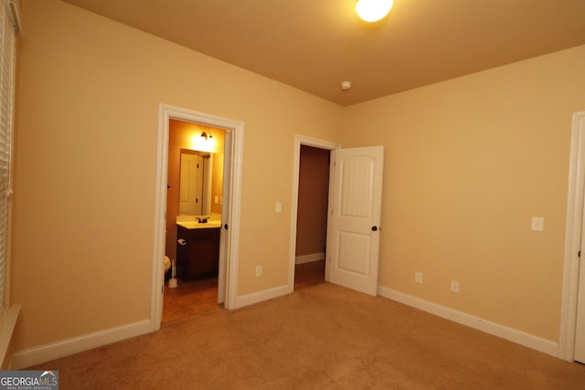 unfurnished bedroom featuring carpet floors and ensuite bathroom