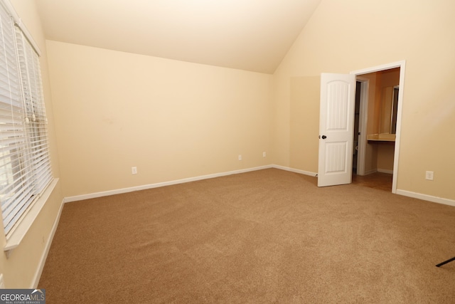 unfurnished bedroom featuring carpet and high vaulted ceiling