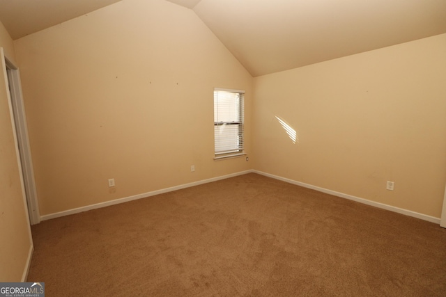 empty room featuring carpet and vaulted ceiling