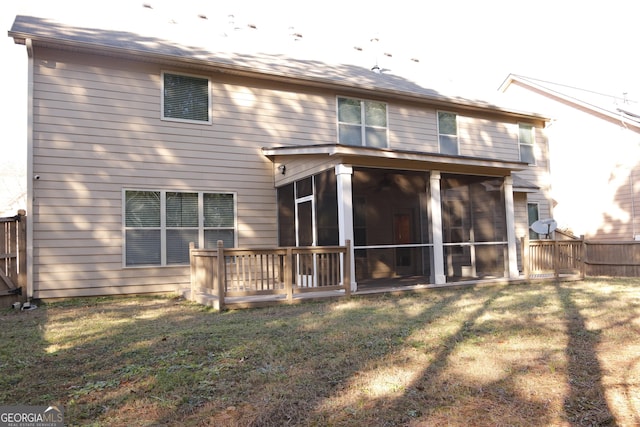 back of property with a sunroom and a lawn