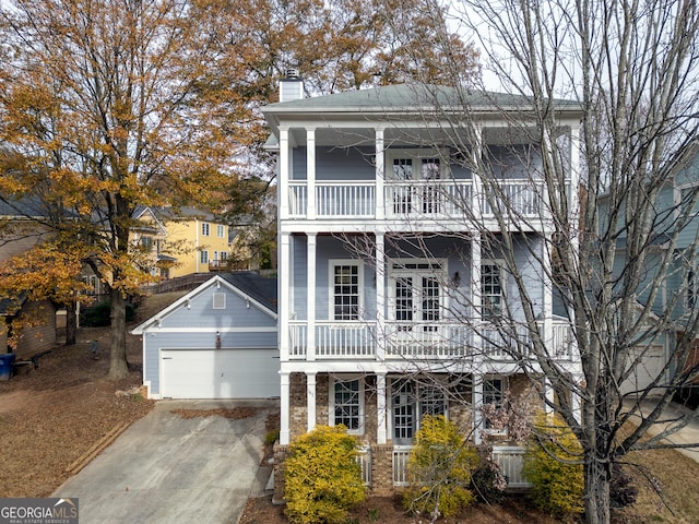 view of front of home with a garage, a balcony, and an outbuilding