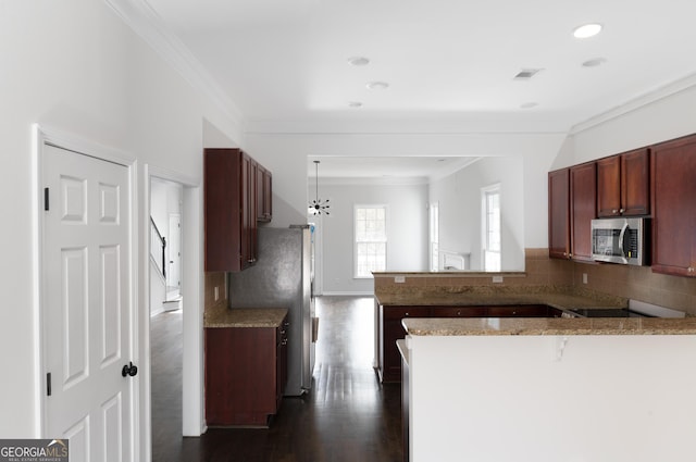 kitchen with dark hardwood / wood-style floors, ornamental molding, appliances with stainless steel finishes, a kitchen bar, and kitchen peninsula