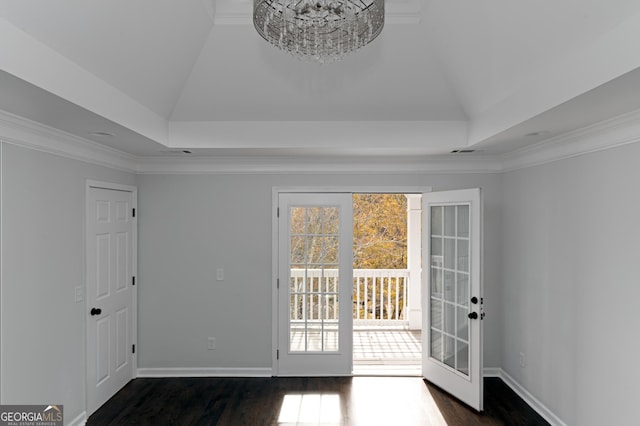 interior space with lofted ceiling, dark hardwood / wood-style flooring, an inviting chandelier, and ornamental molding